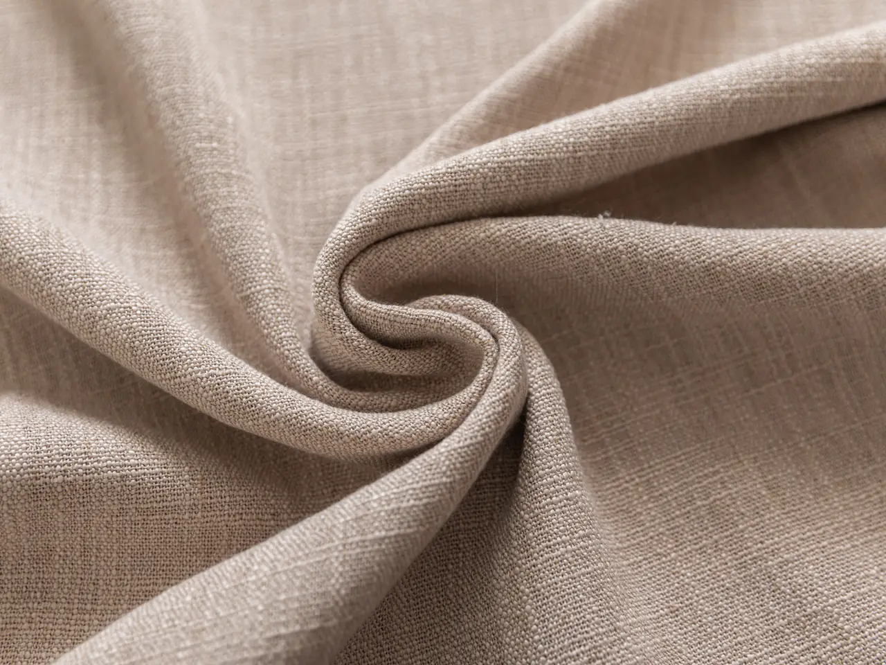 Beige linen folded into a spiral to show its drape