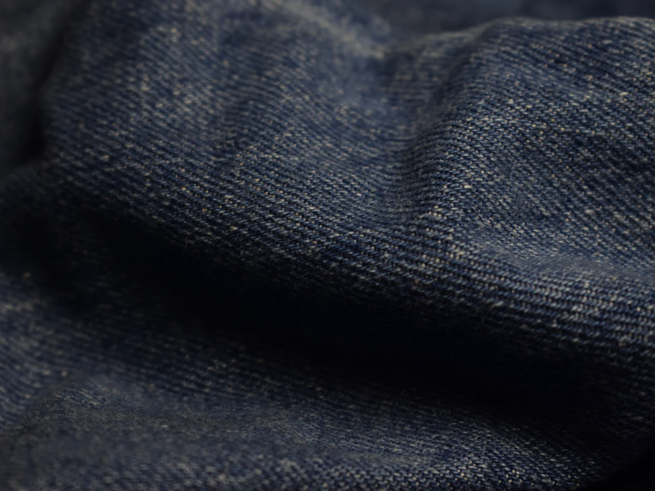 Dark indigo denim showing the diagonal twill line of the weave