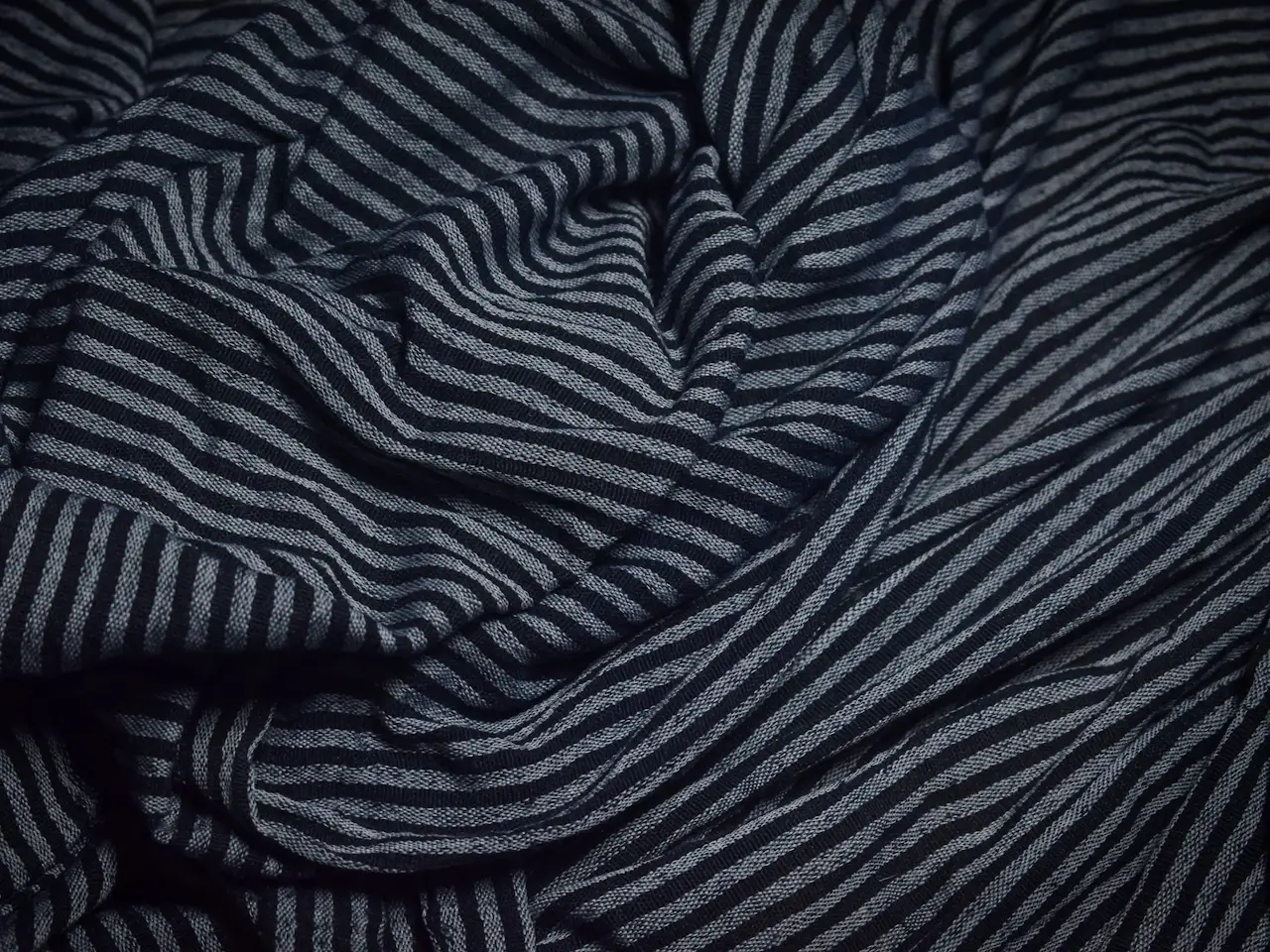 Dark suiting cloth with a fine pinstripe running through the weave
