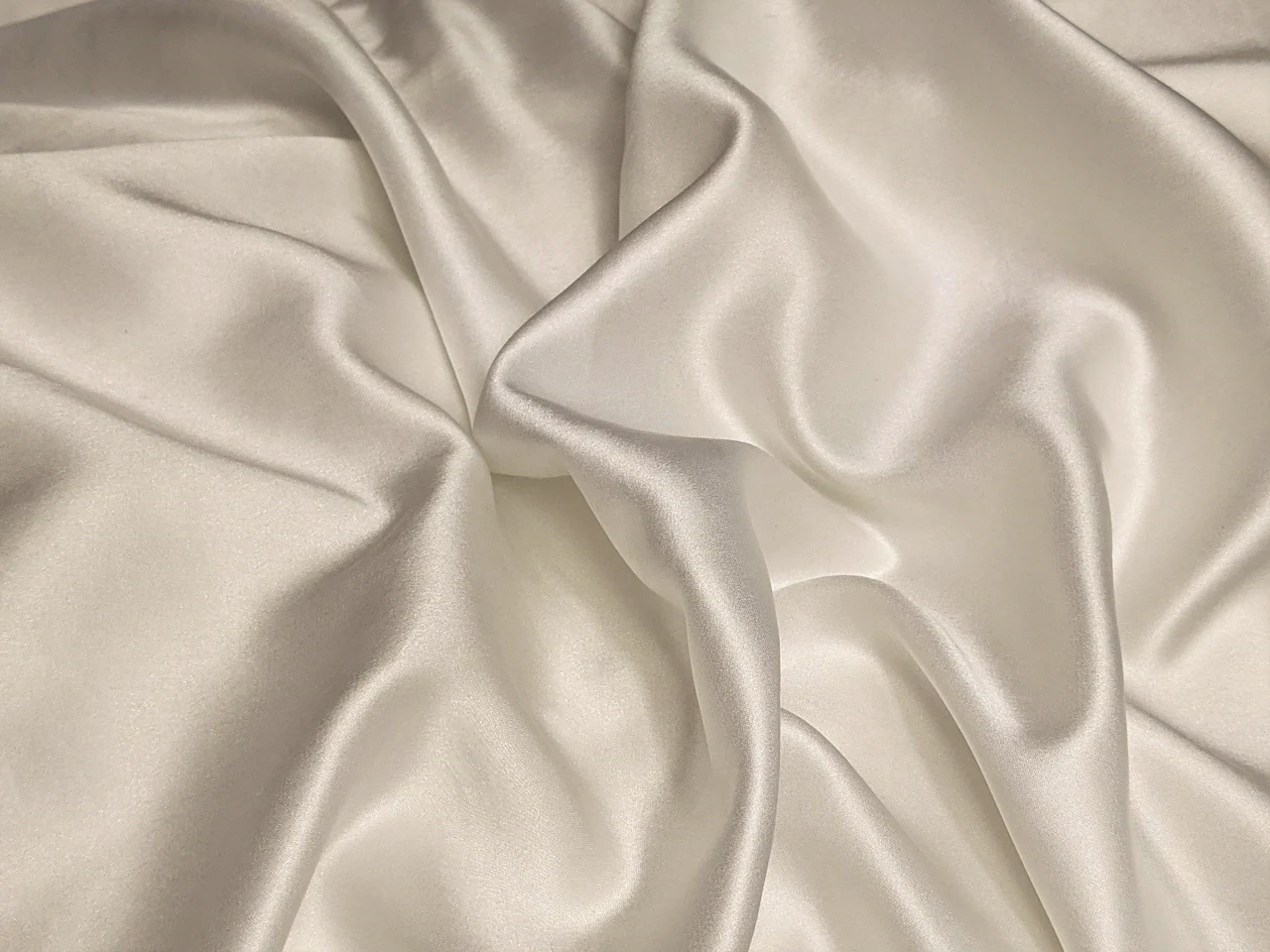 Soft folds of a smooth, lustrous fabric catching the light
