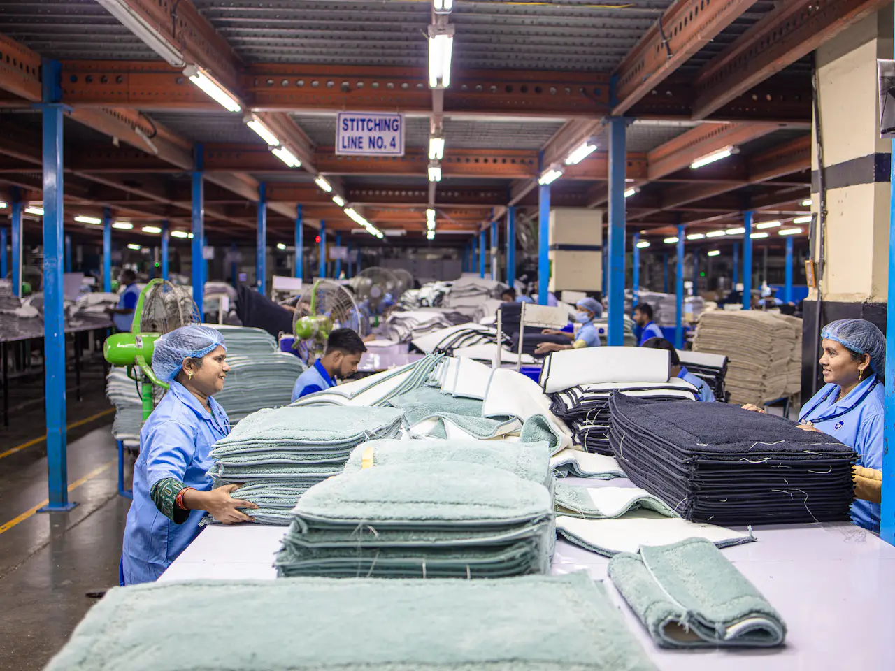 Textile workers sorting finished cloth on a factory floor