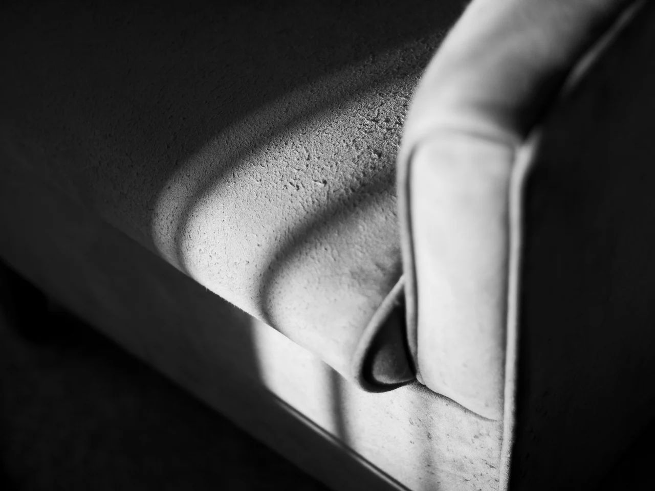 Close-up of a textured armchair covering in raking light