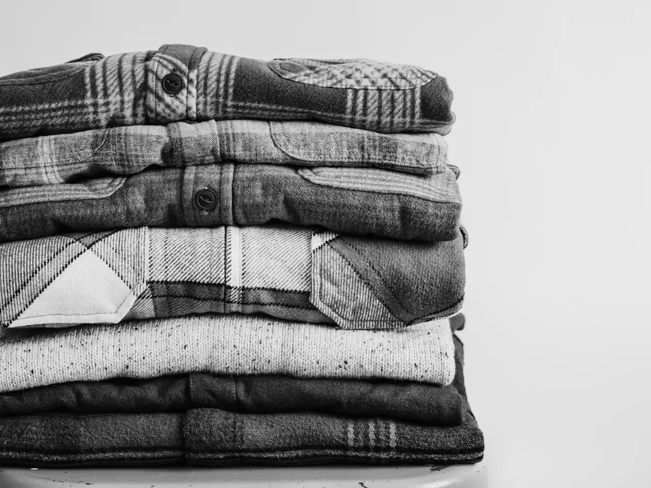 A stack of folded uniform shirts in black and white
